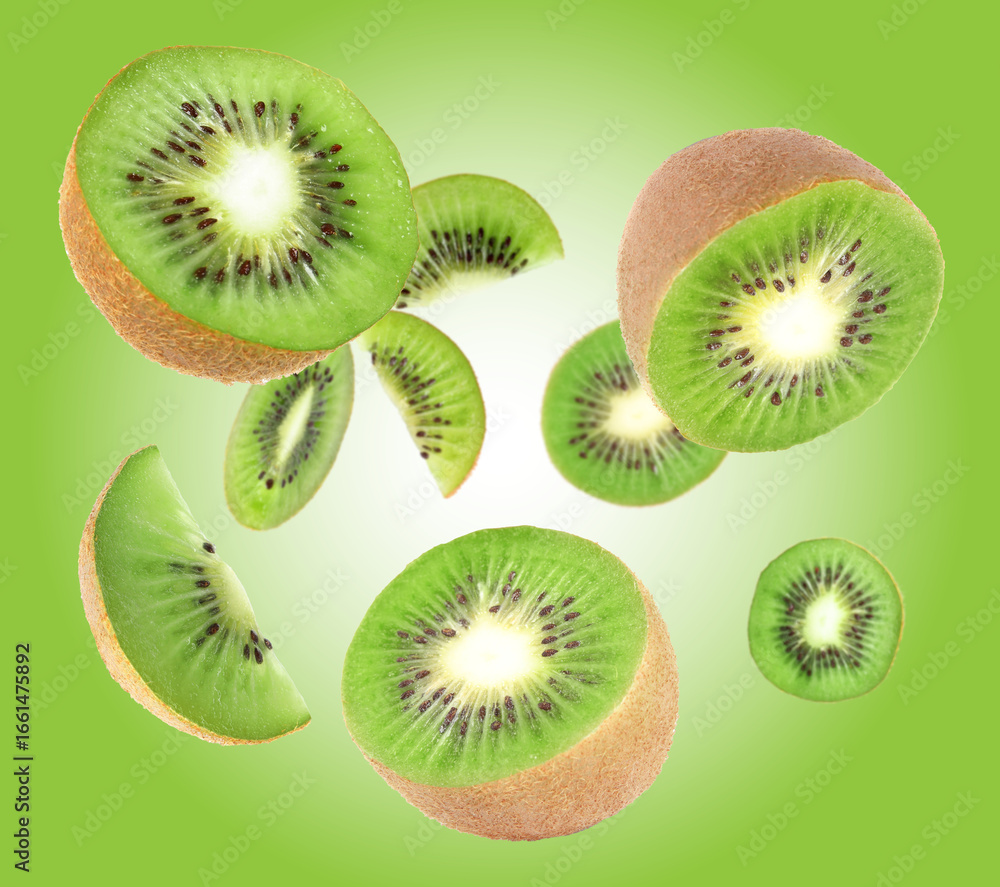 Fototapeta premium Cut fresh kiwi fruits swirling in air against green gradient background