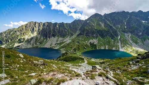 Fototapeta Naklejka Na Ścianę i Meble -  Majestic Twin Alpine Lakes Reflecting Towering Green Mountains Under a Blue Sky.