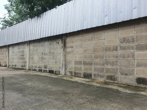Concrete wall with corrugated metal sheet fence