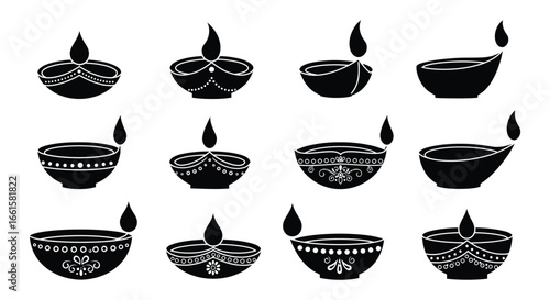 Traditional Indian diyas with intricate designs and flames on white background