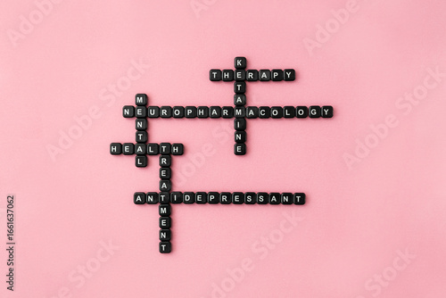 Words neuropharmacology, ketamine therapy and antidepressant made up of black plastic letter blocks on pink background. Mental health treatment crossword. Selective focus