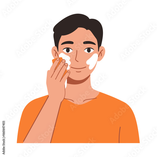 A smiling young man diligently applies a creamy facial cleanser to his face with a sponge, illustrating a modern self-care and grooming routine for a healthy, radiant look.