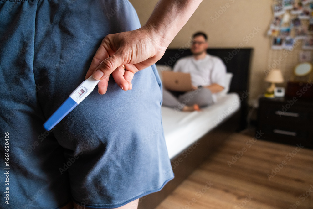 Obraz premium Positive Pregnancy Test Hidden Behind Back