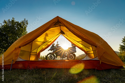 Motorcycle trip to the mountains with a tent. Beautiful sunset in the mountains.