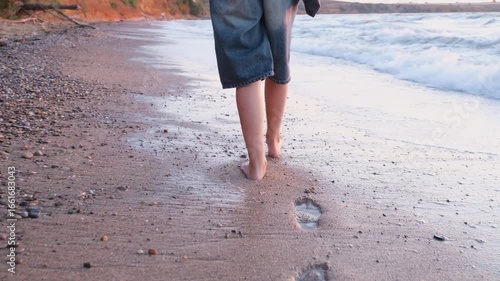 A girl walks by the sea
