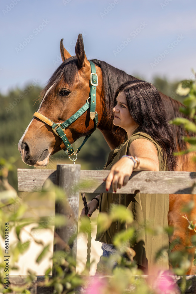 Obraz premium Young woman bonding with a Barb Arabian horse outdoors in summer