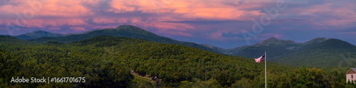 Bilde på lerret Mt Washington Peak at sunset in dramatic weather in the White Mountain National Forest in New Hampshire, with the American flag waving in the wind at early autumn