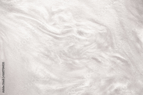 Shimmering silver abstract background. Liquid glitter paint texture waves and swirls. Beautiful shiny white glitter texture. Metallic silver paint close-up as a holiday background.