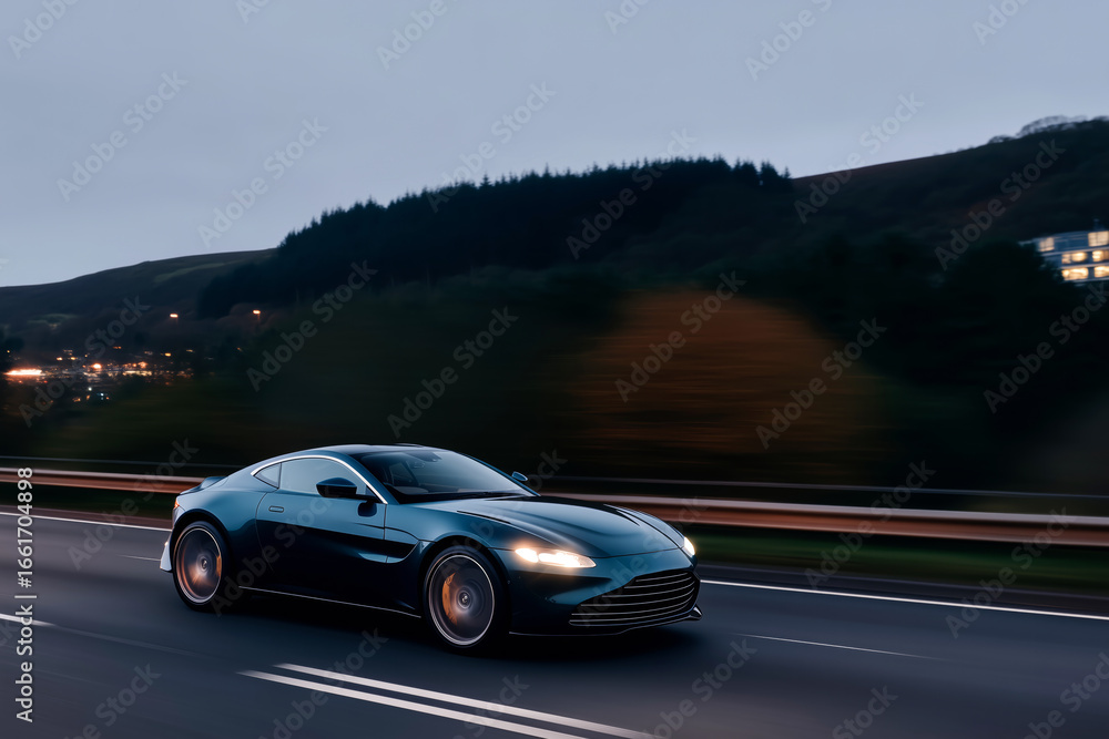 Naklejka premium Blue luxury sports car driving fast on countryside highway at dusk, elegant supercar in motion with blurred background 