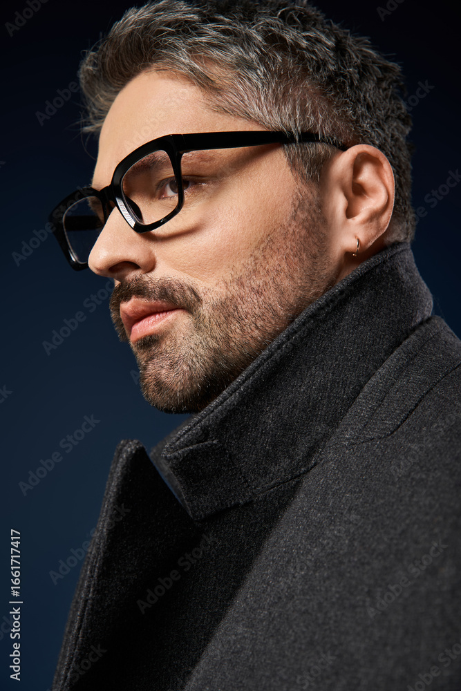 Obraz premium Stylish man in glasses showcasing elegance in a sleek studio setting