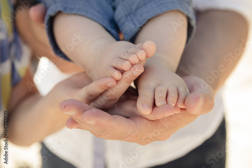Babyfüße in schützender Hand – Symbol für Familie, Geborgenheit und Liebe