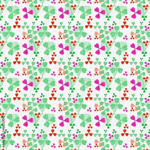 Seamless pattern of vibrant green magenta and red three leaf clover like shapes on a textured white background