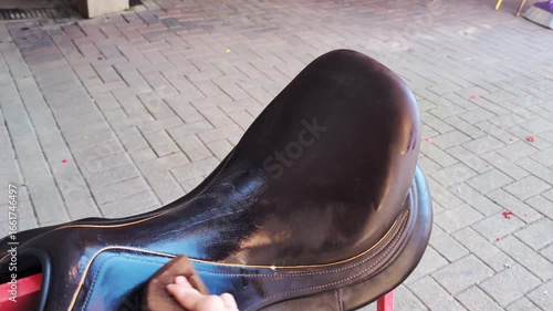 Horse saddle cleaning activity showcasing care and maintenance techniques in a stable.