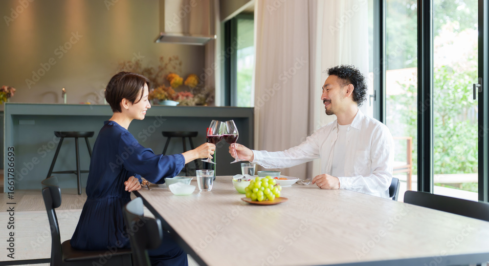 Fototapeta premium モダンなリビングダイニングで赤ワインを飲む夫婦