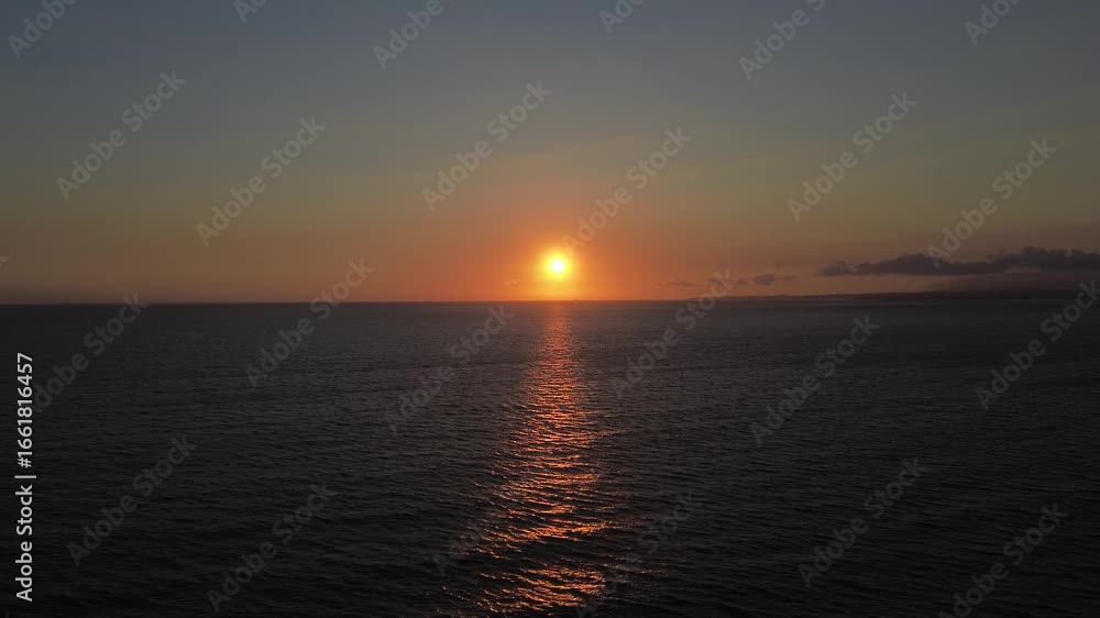 Tranquil sunset over the ocean, drone flies over the water towards the sun. The golden light reflects beautifully on the calm water. Soft clouds drift across the sky, enhancing the serene atmosphere. Tranquil sunset over the ocean, drone flies over the water towards the sun. The golden light reflects beautifully on the calm water. Soft clouds drift across the sky, enhancing the serene atmosphere.