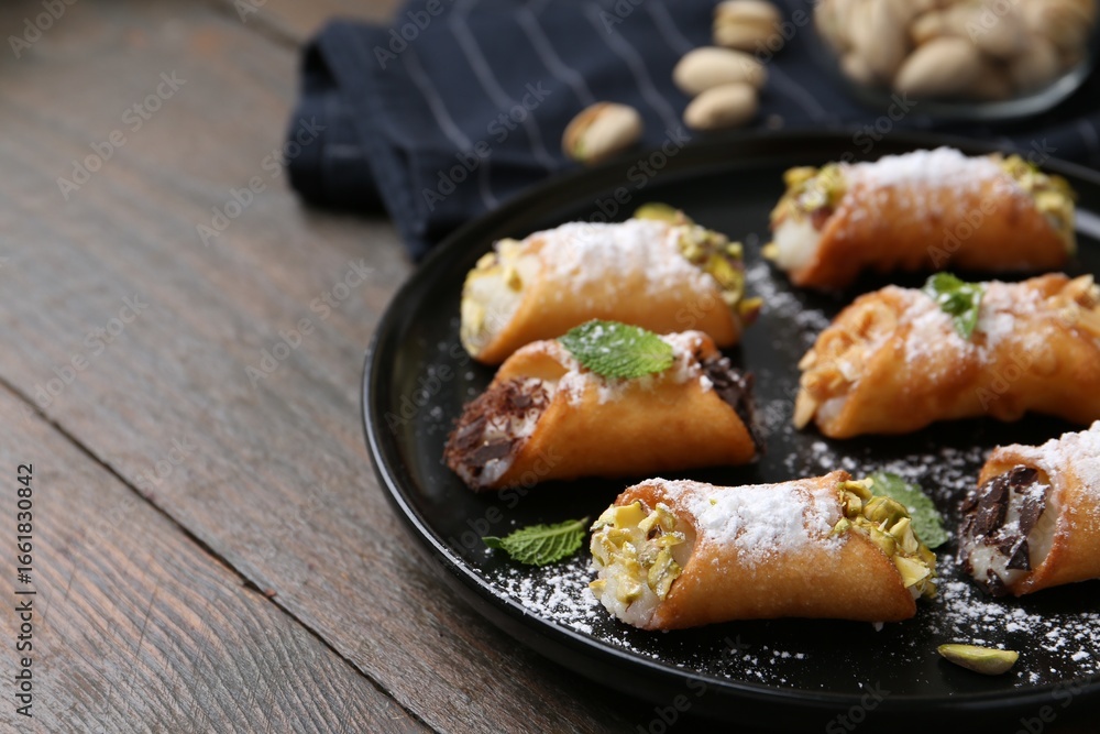 Delicious cannoli with cheese, nuts, powdered sugar, chocolate and mint on wooden table, closeup. Space for text Delicious cannoli with cheese, nuts, powdered sugar, chocolate and mint on wooden table, closeup. Space for text