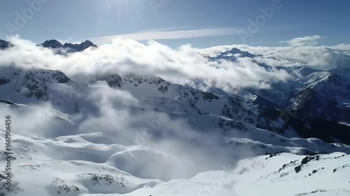 Wallpaper Mural Cinematic Video, 4K: High-angle, wide shot of snow-capped mountain peaks partially obscured by clouds in a vast, winter landscape, conveying a serene and tranquil mood. Torontodigital.ca