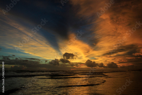 The dramatic afternoon sky on the beach, the sky burning with the tidal waves brings a restless atmosphere between beauty and something horrible.