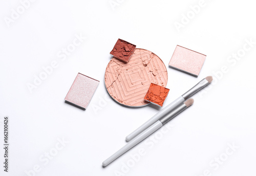 Crushed eyeshadow for makeup and brushes. Cosmetic product sample on white background. Creative layout. Beauty make concept. Top view