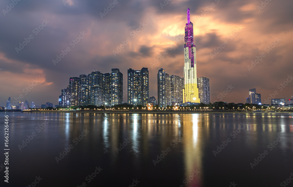 Fototapeta premium Modern skyline of Ho Chi Minh City viewed from Cau Ba Son Bridge, showcasing high-rise buildings reflecting the city's rapid urban development