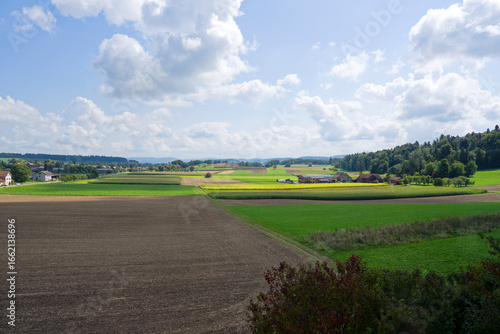 Foto High angle view of scenic rural landscape with Swiss village of Dinhard in the background seen through train window on a sunny summer noon