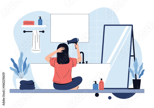 Woman drying her hair with a hair dryer in a modern bathroom