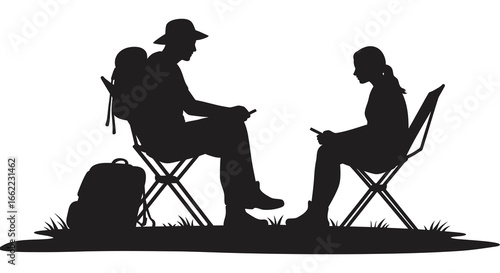 Couple sitting in folding chairs outdoors in silhouette