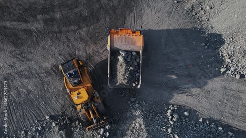 Aerial view Heavy industrial excavator loader of gold ore to dump truck, mining industry open pit mine.