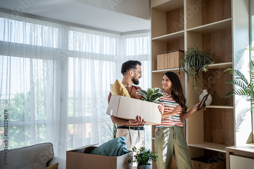 Foto Happy couple arranging belongings in new apartment after moving in