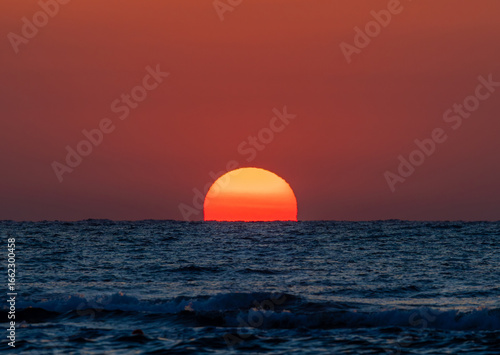A gorgeous sunrise at sea. The big sun rises from the sea water