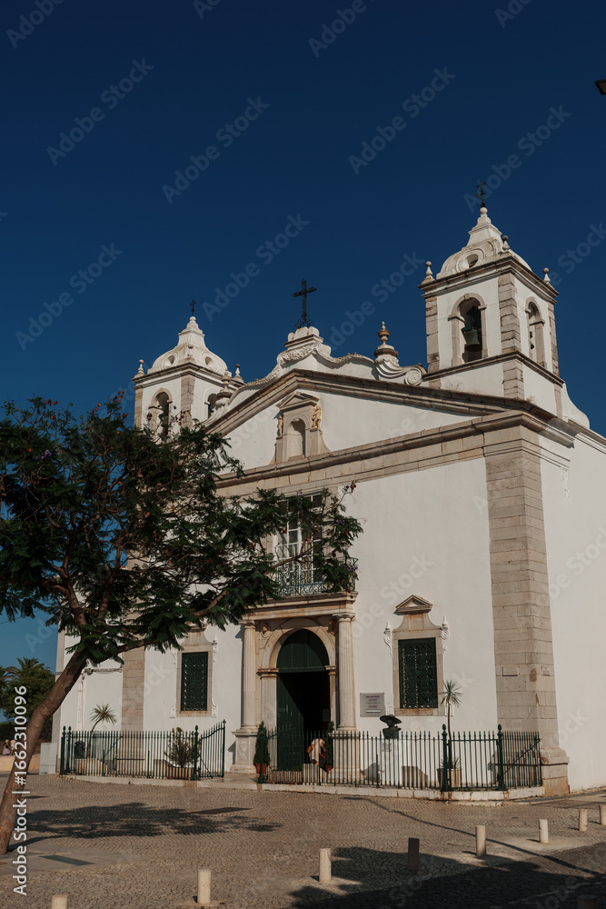 Fototapeta premium White church with twin bell towers in Algarve under clear blue sky