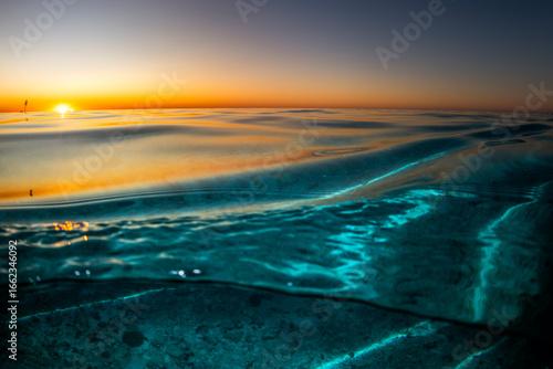 Obraz na plátně Sunset over Heron Island in Queensland with golden light reflecting on the glassy surface of the ocean