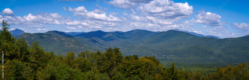 Tranquil summer cloudscape over the White Mountain National Forest in New Hampshire, with soft light drifting across alpine peaks and forested valleys beneath a peaceful sky Tranquil summer cloudscape over the White Mountain National Forest in New Hampshire, with soft light drifting across alpine peaks and forested valleys beneath a peaceful sky