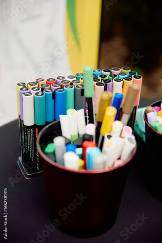 Colorful markers arranged on black table