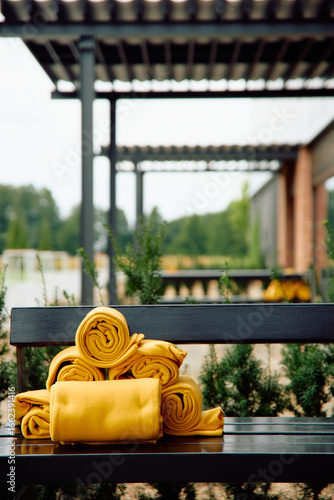 Stack of yellow towels on outdoor bench