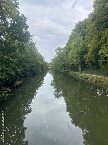 Peaceful Canal with Lush Green Trees and Water Reflections