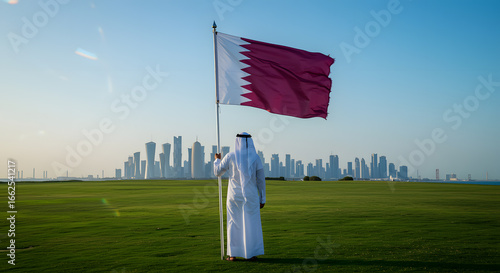 Man Wearing Traditional Middle Eastern Thawb Holding Qatar Flag in Green Park with City Skyline