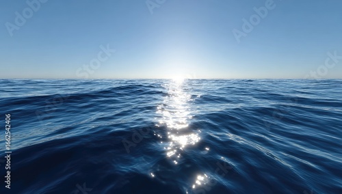 Calm ocean surface, sun reflecting on the water, clear blue sky
