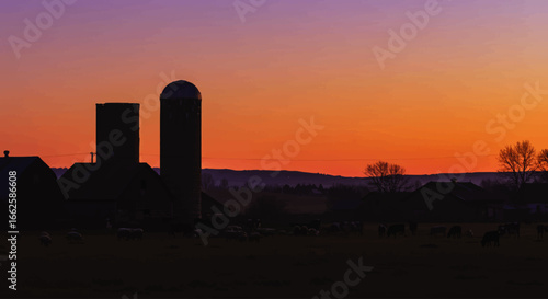 Peaceful farm silhouette with barn and silos against a dramatic and colorful sunset sky in a rural landscape.