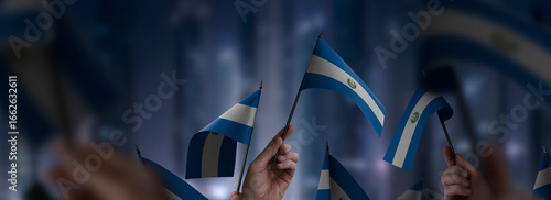 Salvador flags in their hands on a blurred urban background