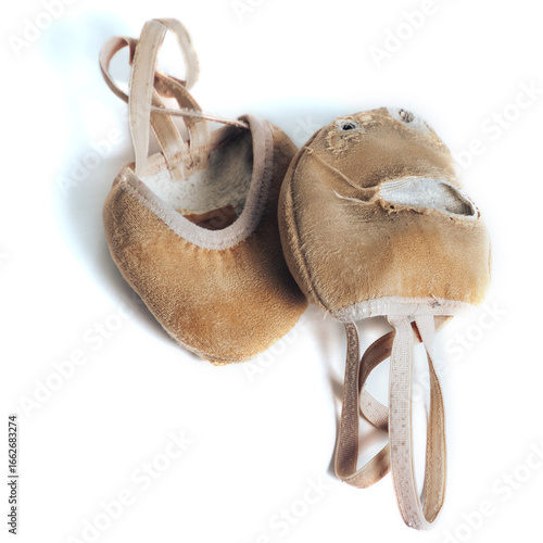 Rhythmic gymnastics shoes wear out very much when actively used during heavy training before competitions.Damaged rhythmic gymnastics shoes worn on white background.