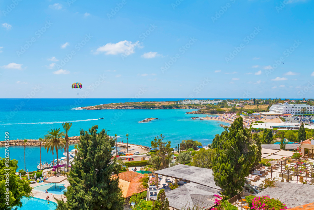Obraz premium The promenade in Paphos, Cyprus, is a perfect spot to unwind — with scenic sea views, gentle waves, and plenty of seating, it’s an ideal place to relax and soak in the Mediterranean atmosphere.