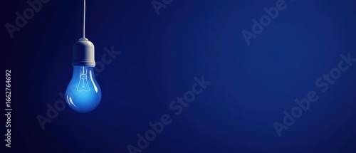 The captivating blue light bulb illuminating a minimalist dark space.