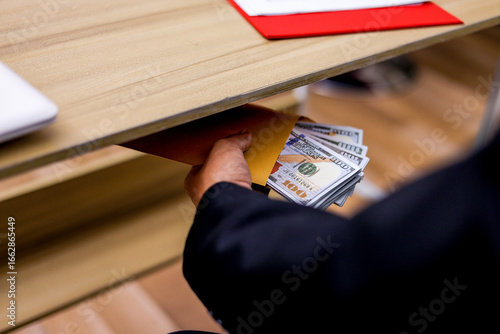 Quadro su tela Businessman Conceals Bribe Money in Yellow Envelope Beneath Table