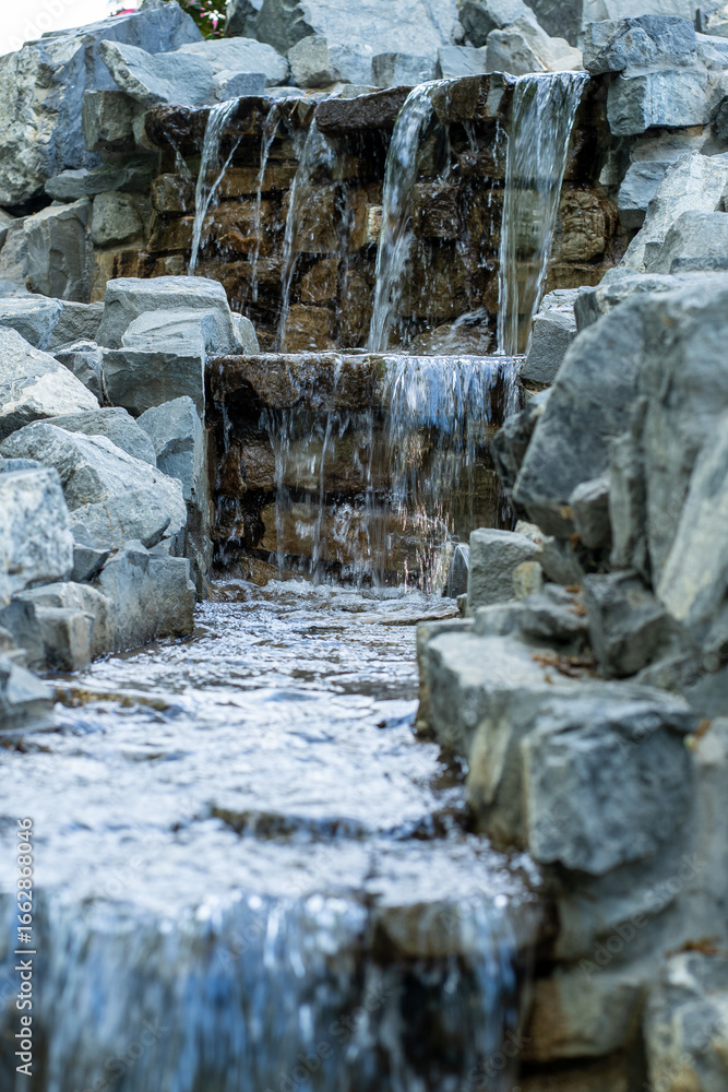 Naklejka premium Vertical tiered stone garden waterfall close-up