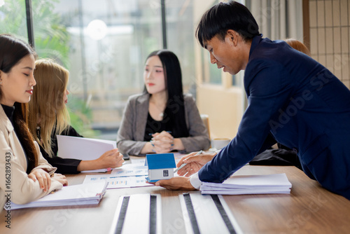 Multiracial professionals in office meeting, businessmen and businesswomen brainstorming ideas, teamwork and leadership fostering cooperation and success.
