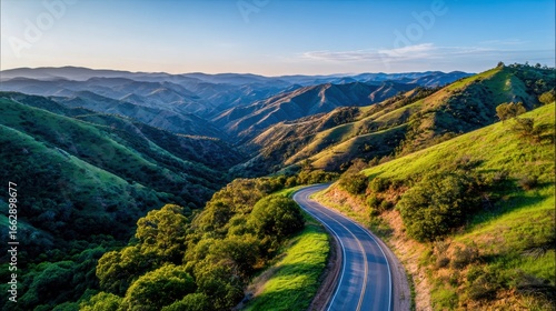 Winding road through green mountains at sunset