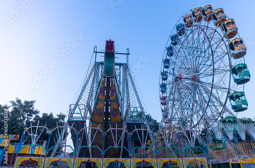 Canvas Print Ferris Wheel or Joint wheel ride running under blue sky on fair ground during the annual dussehra fair