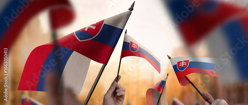 Photography Slovakia flags in their hands on a blurred urban background