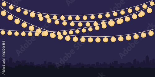 Three strands of string lights hanging over a dark silhouette of a city skyline at nighttime